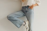 Kaboompics - Woman Posing with Bent Knee in White Blouse and High-Waisted Light Blue Jeans
