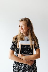 Kaboompics - Young Woman Holding Back to School Sign