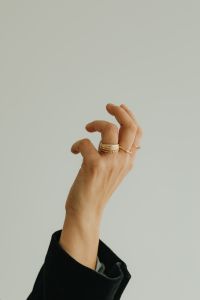Kaboompics - Raised Woman's Hand Showing Stacked Gold Rings