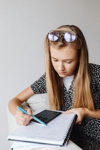 Kaboompics - Teenage Student Studying with Notebook and Calculator