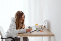 Kaboompics - Teenage Student Writing Homework at Home Desk