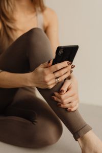Kaboompics - Close-Up of Woman Holding a Smartphone Against Her Leg
