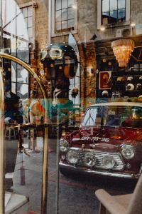 Kaboompics - Red Classic Car Reflected in a Glass Shopfront at LX Factory, Lisbon, Portugal, Urban Travel Scene