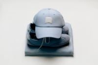 Kaboompics - Blue Cap and Sneakers Stacked on a Sweatshirt