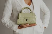 Kaboompics - Woman Holding a Structured Sage Green Handbag at Waist, Neutral Fashion