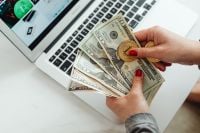 Kaboompics - Hand Holding Bitcoin Coin Over US Dollar Bills