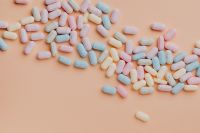 Kaboompics - Pastel Sugar-Coated Candy Scattered across Peach Background with Copy Space