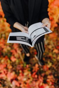 Kaboompics - Vertical Autumn Reading Portrait of a Woman in a Black Jacket and Striped Trousers