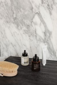 Kaboompics - Skincare Products and Dry Body Brush on Dark Surface