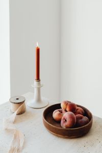 Kaboompics - Burning Taper Candle and Peaches in Minimal Still Life Setting