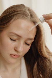 Kaboompics - Woman Applying Facial Serum to Her Forehead with a Glass Dropper