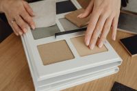 Kaboompics - Close-Up of Hands Arranging Beige and Gray Texture Samples