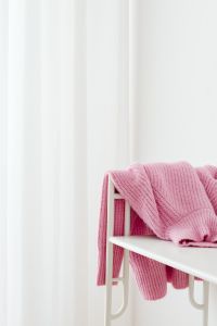 Kaboompics - Pink Sweater Draped on a White Rack