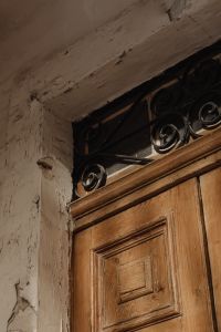 Kaboompics - Old Wooden Door with Wrought Iron Fanlight and Peeling Plaster