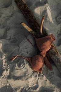 Kaboompics - Brown Swimsuit Top on Sand beside Driftwood