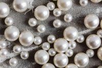 Kaboompics - Large and Small Pearl Beads on Dark Gray Concrete, Horizontal Close-Up Texture
