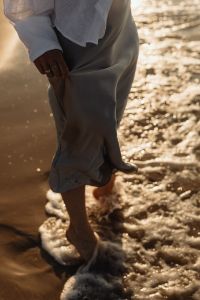 Kaboompics - Barefoot Woman Walking Through Sea Foam in Satin Skirt
