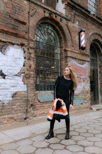 Kaboompics - Full-Body Street Style Portrait by an Arched Industrial Window with Striped Coat