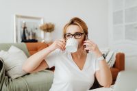 Kaboompics - Coffee Break at Home: Woman Sipping from a Mug While on a Mobile Call