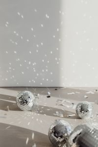 Kaboompics - Two Disco Balls on a Light Floor with Sharp Reflections and Confetti