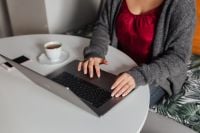 Kaboompics - A brunette woman works with a laptop and a phone