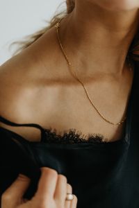 Kaboompics - Gold Necklace on Woman's Shoulder and Black Top