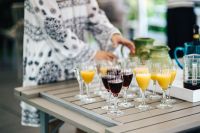 Kaboompics - Person Arranging Orange Juice and Wine Glasses on a Table