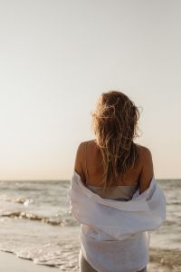 Kaboompics - Faceless Blonde Woman from Behind in White Shirt by the Sea