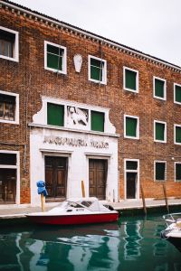Kaboompics - Historic Murano Glass Shop Facade with Carved Stone Entrance and Brickwork, Italy
