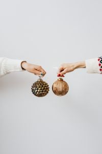 Kaboompics - Christmas Baubles Held Between Hands on a Minimal White Background