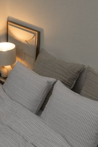 Kaboompics - Warm Lamp and Checkered Pillows on a Bed
