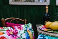 Kaboompics - Lemons on a Colorful Plate beside Parrot Print Pillows, Tropical Garden Party Decor