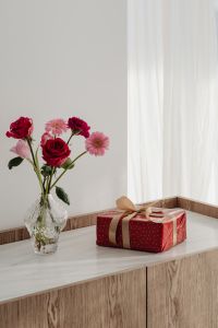 Kaboompics - Glass Vase of Roses and Pink Daisies Beside a Red Gift Box