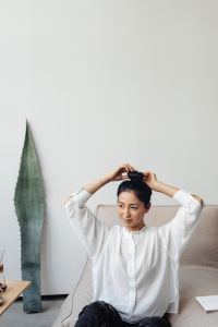 Kaboompics - Woman Tying Her Hair in a Minimal Interior