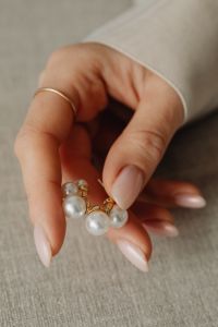 Kaboompics - Woman Holding Pearl Earring Close-Up