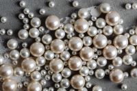 Kaboompics - Dense Scatter of Pearl Beads on Gray Concrete, Horizontal Jewelry Texture