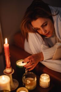 Kaboompics - Woman Relaxing by Candlelight Under a Cozy Blanket