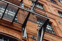 Kaboompics - Black Metal Fire Escape Platform on the Historic Manufaktura Brick Facade, Łódź