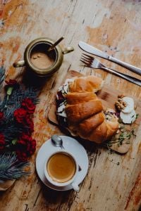 Croissant with goat cheese, beetroot and a cup of coffee for breakfast