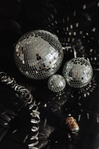Kaboompics - Three Mirror Balls on Black Leather Seat with Curled Silver Ribbon