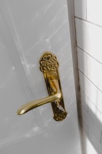 Kaboompics - Vertical Detail of Vintage Gold Door Handle on White Panel and Subway Tile