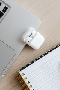 Kaboompics - Close-Up of AirPods Case, Laptop and Notebook