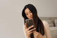 Kaboompics - Woman Checking Her Smartphone While Seated in a Neutral Living Room