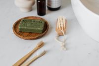 Kaboompics - Olive Green Soap on Wooden Tray with Nail Brushes, Natural Bathroom Hand Care Product Styling