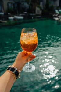 Kaboompics - Aperol Glass and Bracelet against Sparkling Water Bokeh
