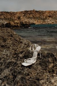 Kaboompics - White Strap Heels on Coastal Rocks beside Shallow Sea