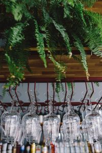 A big bunch of wine glasses hanging from a holder
