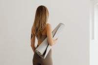 Kaboompics - Woman Carrying a Rolled Yoga Mat With Open Space