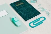 Kaboompics - Teal Calculator and Oversized Paper Clip on a Mint Desk Pad for Modern Math Study