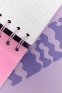 Kaboompics - Spiral Notebook over Wavy Purple Cover
